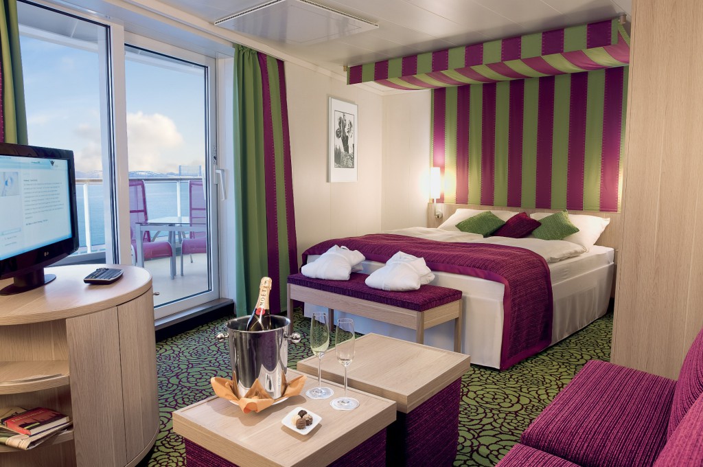 Die großzügigen Suiten bieten auf allen Schiffen der AIDA Flotte ein ganz besonderes Kreuzfahrt-Erlebnis. Dabei muss der Traum von der eigenen Suite nicht unerschwinglich sein: Von der Juniorsuite über die Premium-Suite bis hin zur Deluxe-Variante mit privatem Sonnendeck auf bis zu 87qm bietet AIDA Cruises ein vielfältiges Suiten-Konzept, das jedem Urlaubswunsch gerecht wird.  Für die PREMIUM Gäste der Suiten wird dem hochklassigen Service für alle Gäste an Bord bereits vor dem Ablegen das berühmte i-Tüpfelchen aufgesetzt: Bevor sie ihre Suite beziehen, erwartet sie bei AIDA ein exklusiver Einstieg in den Urlaub. Neben dem Priority Check-in und separatem Service im Terminal, wird auch das Gepäck nach dem Check-in auf die Kabine geliefert. Hier angekommen, erwartet die Gäste ein persönlicher Willkommensbrief vom Kapitän und dem General Manager sowie eine Flasche Champagner, jeden Tag werden außerdem frisches Obst und Pralinen bereitgestellt. Um es auch den kleinen Suiten-Gästen an nichts fehlen zu lassen, liegen wie für die Erwachsenen auch Kinder-Bademäntel, Bade-Slipper und eine kleine Aufmerksamkeit bereit. Auf die Eltern warten im Bad Pflegeprodukte wie Peelingseife und Augenmaske der Luxusmarke Thalgo sowie frische Blumen. Gästen der Suiten steht über das Housekeeping exklusiv der neue 24-Stunden-Reinigungsservice zum regulären Preis zur Verfügung.  Auch kulinarisch werden Gäste der Suiten besonders verwöhnt: Bereits am Anreisetag sind sie zu einem 3-Gänge-Menü im Rossini eingeladen, in einem À-la-carte-Restaurant wird an jedem Morgen das Frühstück serviert. Auf jeder Reise wartet außerdem die Einladung zu einem Empfang mit dem General Manager und dem Reiseberater an Bord, das exklusiv für Suitengäste arrangiert wird. Um allen nach einem erlebnisreichen Urlaubstag eine himmlische Nachtruhe zu bescheren, bereitet der Kabinenservice die Suiten jeden Abend für die Gäste vor. Die Betten sind mit Anti-Allergie-Kissen und -Decken der Premiummarke Mühldorfer ausgestattet. Als besonderes Angebot dürfen sich die Gäste ab sofort aus dem AIDA Kissenmenü ihren persönlichen Liebling auswählen. Mit fünf unterschiedlichen Kissen von der klassischen Daune über Füllungen mit duftendem Arvenholz bis hin zum Nacken- und extra großem Seitenschläferkissen liegt für jeden Schlaftyp das richtige Luxusformat bereit. Die Damen dürfen sich über ein weiches Lady-Kopfkissen freuen, die Herren erwartet ein Daunenkissen mit stützendem Gänsefederkern.  Um die Reise entspannt ausklingen zu lassen, sind Suitengäste am Abreisetag auf allen Schiffen mit Wellnessoase herzlich in den exklusiven Wellness-Bereich eingeladen. Als Erinnerung an die Reise warten außerdem ein Farewell-Brief und ein Foto vom exklusiven Empfang auf die Suitengäste.